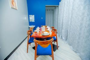 a wooden table with chairs and cups on it at Niwa Apartments in Dar es Salaam