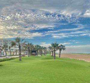 a golf course with palm trees and a building at Porto Said Resort Rentals num374 in Port Said
