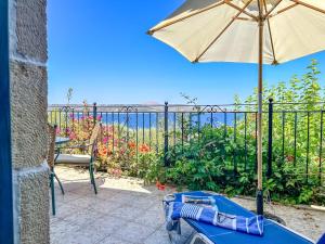 - une terrasse avec un parasol et une table dans l'établissement Muses Kalami, à Sinoikismós Plakálona