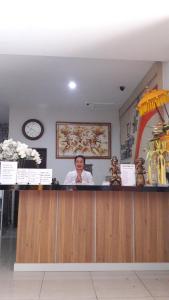 a woman sitting at a counter in a restaurant at The Agung Residence in Seminyak