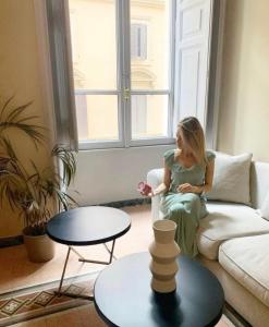 uma mulher sentada num sofá numa sala de estar em Glance in Rome em Roma