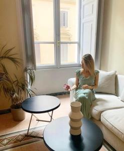 a woman sitting on a couch in a living room at Glance in Rome in Rome