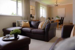 a living room with a brown couch and a table at Amroth House in Cardiff