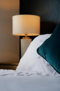 - un lit avec un oreiller vert et une lampe dans l'établissement Amroth House, à Cardiff