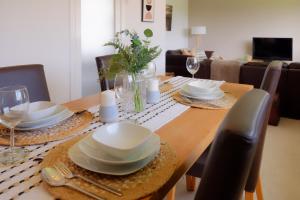 - une table à manger avec des assiettes et de la vaisselle dans l'établissement Amroth House, à Cardiff