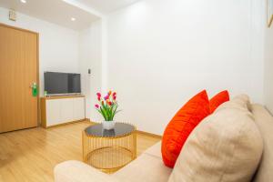 uma sala de estar com um sofá com almofadas vermelhas em Sumitomo11 Apartment 5-39 Linh Lang em Hanói