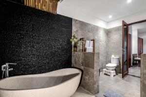 ein Badezimmer mit Badewanne und Toilette in der Unterkunft Villa Iris by BaliSuperHost in Dalung