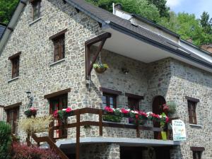 ein Steinhaus mit Blumen auf dem Balkon in der Unterkunft Villa Clara in La-Roche-en-Ardenne