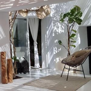 a room with a rattan chair and a plant at Casa BOHO in Alaminos