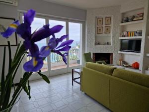 a living room with a green couch and purple flowers at ViSte in Porto Santo Stefano