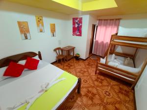 a bedroom with two beds and a bunk bed and a chair at Yuki Lodge - El Nido PH in El Nido