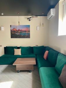 uma sala de estar com um sofá verde e uma mesa de centro em Апартаменти Underground&SPA em Lviv