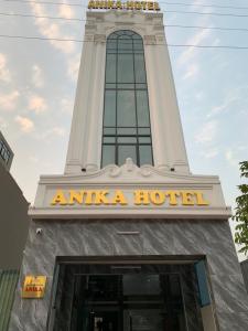 uma torre do relógio com uma placa de hotel em frente em Anika Hotel em Ha Long