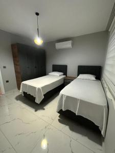 2 bedden in een kamer met 2 bedden, waarvan 1 tweepersoonsbed en 1 eenpersoonsbed. bij LUXURY SUMMER HOUSE in Dalaman