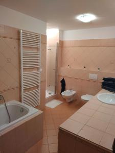 een badkamer met een bad, een toilet en een wastafel bij Apartmán u kostela in Pec pod Sněžkou