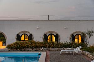 a building with a swimming pool in front of it at Masseria Gorgognolo in Ostuni