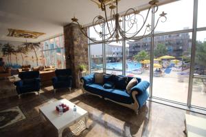 a living room with a blue couch and a pool at Ozkaptan Aqua Otel in Marmara