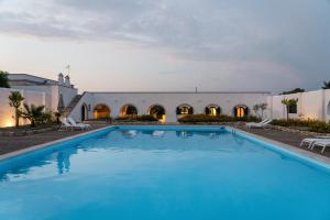 a large swimming pool in front of a building at Masseria Gorgognolo in Ostuni