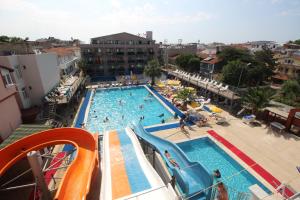 une grande piscine avec un toboggan et des personnes y séjournant dans l'établissement Ozkaptan Aqua Otel, à Marmara