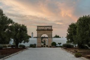 a clock tower in the middle of a driveway at Masseria Gorgognolo in Ostuni