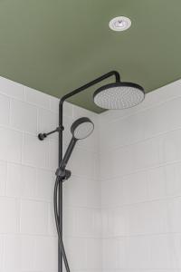 a shower with a shower head and two lights at Hangon Asema 14 in Hanko