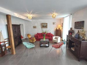 a living room with a red couch and chairs at Maison familiale bord de mer in Douarnenez
