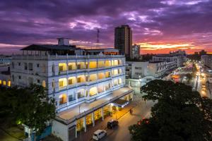 a building on a city street at sunset at Sentrim Castle Royal Hotel in Mombasa