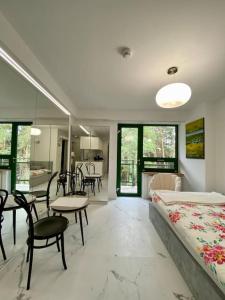 1 dormitorio con 1 cama, mesa y sillas en Mirror Apartment en Serock