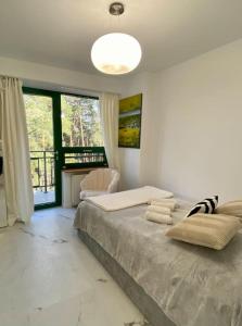a bedroom with a large bed and a large window at Mirror Apartment in Serock