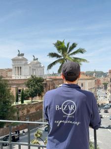 un homme debout sur un balcon donnant sur une ville dans l'établissement Salotto Monti, à Rome