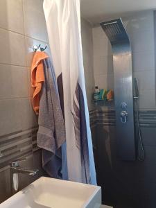 a bathroom with a shower curtain and a sink at To spiti tis Xaras in Agia Anna
