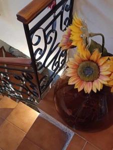 a vase of sunflowers sitting on a table next to a staircase at To spiti tis Xaras in Agia Anna