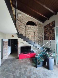 een woonkamer met een trap en een bakstenen muur bij CA CENTOSA ARTISTIC HOUSE villa storica ristrutturata con patio e giardino in Cittadella