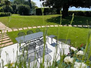 una mesa de picnic y sillas en un parque en Appartamenti Villa Andrea en Garda