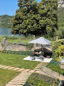 une terrasse avec un parasol, une table et des chaises dans l'établissement Appartamenti Villa Andrea, à Garde