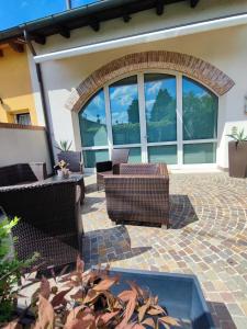 un patio con sedie in vimini e una grande finestra di CA CENTOSA ARTISTIC HOUSE villa storica ristrutturata con patio e giardino a Cittadella