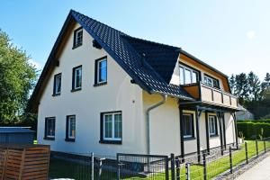 una casa bianca con tetto nero di Ferienappartement zur Granitz a Seerams