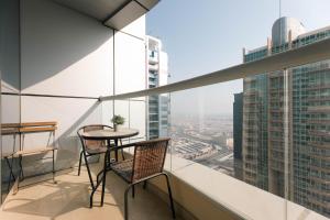 - Balcón con mesa y sillas en un edificio en Charming Condo With Balcony In The Heart of JLT en Dubái