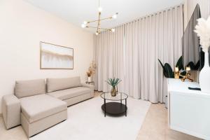 Sala de estar blanca con sofá y mesa en Charming Condo With Balcony In The Heart of JLT en Dubái