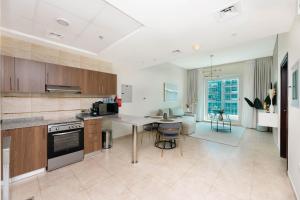 a large kitchen with a table and a dining room at Charming Condo With Balcony In The Heart of JLT in Dubai