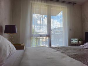 een slaapkamer met een bed en een groot raam bij Rea Home Apartment in Sofia