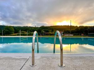 a swimming pool with two metal handles in front of it at Beche EcoCamp in Santa Eulalia