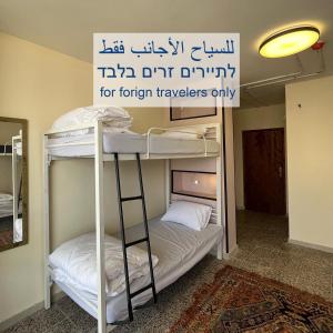 a room with two bunk beds with a sign above them at Bethlehem City Hostel in Bethlehem