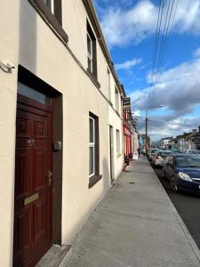 a building with a red door on the side of a street at Central Town House, Moville in Moville