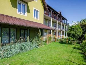 un edificio amarillo con un patio delante en Stacja Akacja en Kąty Rybackie