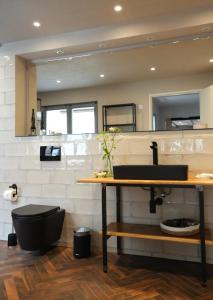 a bathroom with a black toilet and a sink at Modernes Ferienhaus nahe Spreewald-Idylle in Luckau