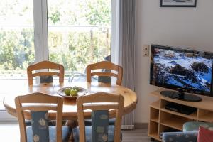 a dining room table with two chairs and a television at LM5-17 - Ferienwohnung Typ AB Komfort in Schottwarden