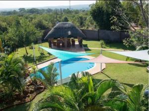 a swimming pool in a yard next to a house at Room in Villa - Zambezi Family Lodge - Leopard Room in Victoria Falls