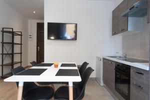 a kitchen with a white table and black chairs at Appartement moderne et élégant quartier Saint-Jean Perpignan in Perpignan