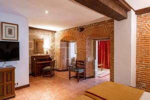 a living room with a brick wall and a bedroom at Parador de Plasencia in Plasencia